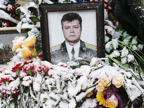 Flowers covered in snow are seen lying in front of the portrait of Oleg Peshkov, a Russian pilot of the downed SU-24 jet, in Lipetsk, Russia, Dec.r 2, 2015.   REUTERS/Maxim Zmeyev