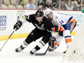 Pittsburgh Penguins centre Sidney Crosby shields the puck from New York Islanders defenceman Thomas Hickey (14) during overtime at the CONSOL Energy Center. (Charles LeClaire/USA TODAY Sports)