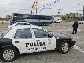 A Greyhound bus passes a police cruiser as it heads to the terminal Thursday, March 31, 2016, in Richmond, Va. (AP Photo/Steve Helber)