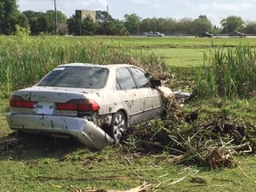 The photo shows a car after it plunged into a pond at Royal Palm Cemetery, Thursday, March 31, 2016, in St. Petersburg, Fla. Authorities say three teenage girls were found dead inside the stolen car after driving into a pond while fleeing sheriff's deputies in Florida. (Tony Marrero/The Tampa Bay Times via AP)
