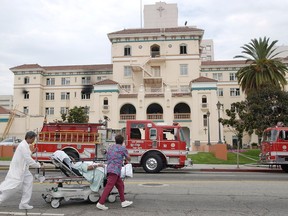 In this July 22, 2003, file photo, nurses evacuate a patient after a fire broke out at the formerly named Queen of Angels-Hollywood Presbyterian Medical Center in L.A. The hospital was the subject of a "ransomware" computer network extortion plot. In the attacks, hackers lock up an institution's computer network and demand payment to reopen them. The U.S. and Canada have now issued a joint cyber alert. (AP Photo/Nick Ut, File)