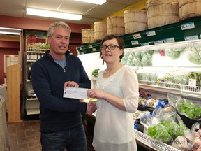 Keenan Kusan/For The Sudbury Star
Tom Fortin and Peggy Baille exchange a $10,000 cheque at Eat Local Sudbury. Baille said the funds are part of a $75,000 fundraising initiative.