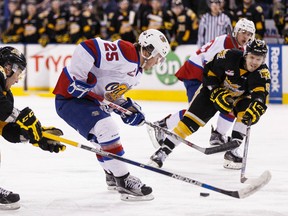 Edmonton's Lane Bauer (25) is checked by Brandon's Ivan Provorov (9) and Jayce Hawryluk (8) during a WHL playoff game between the Edmonton Oil Kings and the Brandon Wheat Kings at Rexall Place in Edmonton on March 31, 2016.