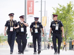 Police officers walk through the athletes' village at the 2015 Pan Am Games in Toronto on July 9, 2015. The recent furor over comments by Toronto's outgoing deputy chief of police about cutting officers to save money focused the spotlight anew on policing costs that keep rising even as Canada's crime rate plunges and its economy sputters. (THE CANADIAN PRESS/Darren Calabrese)