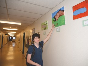 Stuart Remillard shows his art exhibit which lines the third floor hallway at Spruce Grove Composite High School. - Photo by Marcia Love