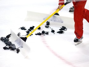 Rink workers shovel plastic rats off the ice during the Florida Panthers’ game against the New Jersey Devils at BB&T Center Thursday. (Robert Mayer/USA TODAY Sports)