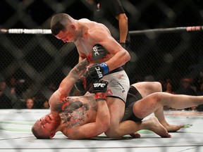Nate Diaz, top, punches Conor McGregor during their UFC 196 welterweight mixed martial arts bout Saturday, March 5, 2016, in Las Vegas. (AP Photo/Eric Jamison)