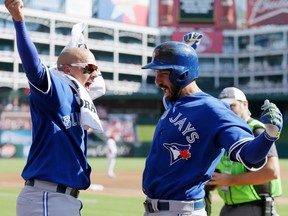 Toronto Blue Jays first baseman Chris Colabello celebrates his home run against the Texas Rangers with second baseman Ryan Goins in Arlington, Texas, on Oct. 12, 2015. (AP Photo/LM Otero)