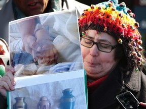 Jennifer Neville-Lake holds pictures of her children Harry and Millie holding hands in hospital before they died outside the Newmarket court on March 29, 2016 where Marco Muzzo was just sentenced for a drunk-driving crash that claimed their lives. (Craig Robertson/Toronto Sun/Postmedia Network)