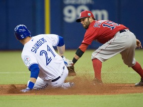 Toronto Blue Jays' Michael Saunders is tagged out at second by Boston Red Sox second baseman Dustin Pedroia while trying to stretch a single during fourth inning spring training baseball game Friday in Montreal. (THE CANADIAN PRESS/Paul Chiasson)