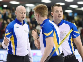 Alberta skip Kevin Koe (left) celebrates his win over Manitoba with third Marc Kennedy and lead Ben Hebert after a draw in Page playoff competition at the Tim Hortons Brier curling championship, Saturday March 12, 2016, in Ottawa. (THE CANADIAN PRESS/Justin Tang)