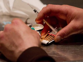 A man prepares heroin to be injected at the Insite safe injection clinic in Vancouver in 2011.