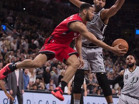 Toronto Raptors guard Cory Joseph passes the ball around San Antonio Spurs center Tim Duncan during the second half at the AT&T Center.  (Jerome Miron/USA TODAY Sports)