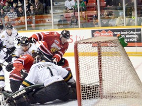 London goalie Tyler Parsons does the splits to keep the Owen Sound Attack's Liam Dunda (right) from jamming the puck into the net during the Knights 5-2 win on Sunday in Ontario Hockey League play-off action. (Bill Walker, Postmedia Network)