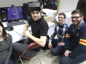 Queen's University students, from left, Brianna Rubin, Jonathan Stanford, Graham McGregor and Daniel Clarke gather around their virtual reality version of Pac-Man at a showcase of computer science at Queen's University on March 31. (Michael Lea/The Whig-Standard)