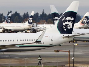 A ground crew member walks near Alaska Airlines planes parked at Seattle-Tacoma International Airport in SeaTac, Washington, in this file photo taken October 30, 2013. REUTERS/Jason Redmond/Files