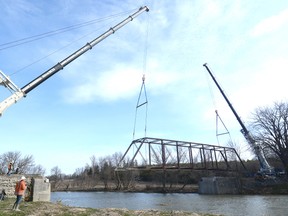 Large cranes from Modern Crane remove the historic 110-year-old Trafalgar Bridge from its rural setting over the Thames River near Motherwell last Wednesday, March 30. SCOTT WISHART POSTMEDIA NETWORK