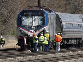 Emergency personnel examine the scene after an Amtrak passenger train struck a backhoe, killing two people, in Chester, Pennsylvania, April 3, 2016. The southbound Palmetto train running from New York to Savannah, Georgia, had about 341 passengers and seven crew members aboard when it struck the backhoe. REUTERS/Dominick Reuter
