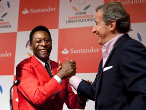 FILE - In this Wednesday, June 22, 2011 file photo, Juan Pedro Damiani, president of Uruguay's Penarol soccer club, right, shakes hands with Brazilian soccer legend Pele after a news conference in Sao Paulo, Brazil. (AP Photo/Victor R. Caivano, file)