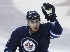 Winnipeg Jets centre Adam Lowry catches an airborne puck against the Minnesota Wild in Winnipeg on Sun., April 3, 2016. Kevin King/Winnipeg Sun/Postmedia Network