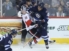 Winnipeg Jets defenceman Dustin Byfuglien drops Ottawa Senators forward Mark Stone with a body check during NHL action in Winnipeg on March 30, 2016. (Kevin King/Winnipeg Sun/Postmedia Network)