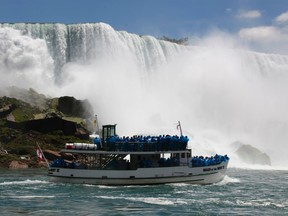 In this Friday, June 11, 2010 file photo, tourists ride the Maid of the Mist tour boat at the base of the American Falls in Niagara Falls, N.Y. (AP Photo/David Duprey, File)
