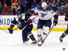 St. Louis Blues centre David Backes fights for control of the puck with Colorado Avalanche defenceman Nick Holden during third-period NHL action in Denver on April 3, 2016. (AP Photo/David Zalubowski)