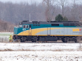 Firefighters look at damage to the front of VIA Rail passenger train after it collided with a car, killing it's two occupants, at a level crossing with cross bucks and lights on Melbourne Drive north of Melbourne, Ont. on Monday April 4, 2016.  The driver and a passenger of a car, which was travelling southbound on the county road shortly after 10:30 a.m., were pronounced dead a the scene, according to OPP.  None of the 88 passengers on train 72, en route from Windsor to London and Toronto, were injured.  Craig Glover/The London Free Press/Postmedia Network