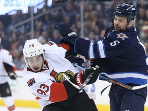 Winnipeg Jets defenceman Mark Stuart (right) hits Ottawa Senators centre Mika Zibanejad during NHL action in Winnipeg on Wed., March 30, 2016. (Kevin King/Winnipeg Sun/Postmedia Network)