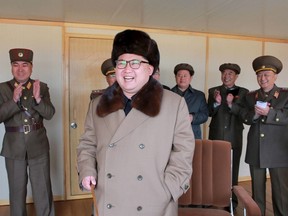 North Korean leader Kim Jong Un, centre, smiles as he watches the test of a new type of anti-air guided weapon system in this undated photo released by North Korea's Korean Central News Agency (KCNA) on April 2, 2016. (REUTERS/KCNA)