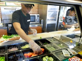 FILE - In this March 3, 2015, file photo, workers make sandwiches at a Subway sandwich franchise in Seattle. (AP Photo/Ted S. Warren, File)