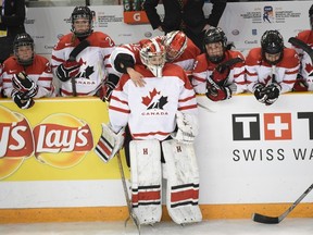 Dejected Canadian goalie Emerance Maschmeyer is comforted following the United States 1-0 victory in overtime gold medal action at the women's world hockey championships in Kamloops, B.C. on April 4, 2016. (THE CANADIAN PRESS/Ryan Remiorz)