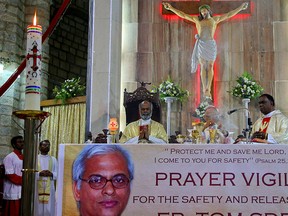 A photograph of Indian Catholic priest Tom Uzhunnalil is displayed during a prayer for his release at the St. Francis Xavier's Cathedral, in Bangalore, India, Monday, April 4, 2016. (AP Photo/Aijaz Rahi)