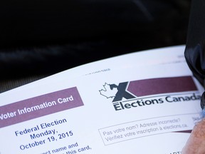 A voter holds his Elections Canada voter information card at a polling station in the Montreal riding of Vaudreuil-Soulanges on election day, Monday, October 19, 2015. THE CANADIAN PRESS/Graham Hughes