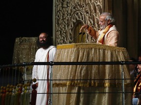 India's Prime Minister Narendra Modi addresses the gathering as Sri Sri Ravi Shankar (L), a well known guru, watches during World Culture Festival on the banks of the river in New Delhi, India, March 11, 2016. REUTERS/Adnan Abidi