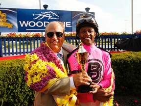 Trainer Mark Casse (left) and jockey Patrick Husbands celebrate with the trophy after their horse Lexie Lou won the 155th running of the Queen’s Plate. Casse will be inducted into the Canadian Horse Racing Hall of Fame in August. (Reuters)