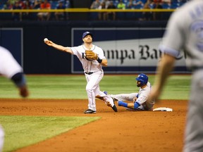Jays’ Jose Bautista slides into second base while interfering with Rays’ Logan Forsythe during the ninth inning of last night’s game. (AP)