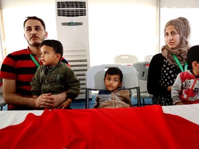 Syrian refugee children play as they wait with their families to register their names at the US center for refugees during a media tour held by the US embassy in Amman, Jordan, Wednesday, April 6, 2016. (AP Photo/Raad Adayleh)