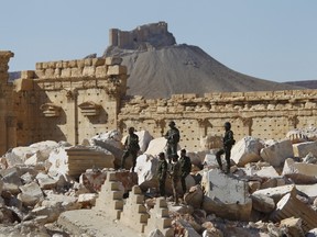 Syrian army soldiers stands on the ruins of the Temple of Bel in the historic city of Palmyra, in Homs Governorate, Syria in this April 1, 2016 file photo. The Fakhreddin's Castle is seen in the background. REUTERS/Omar Sanadiki/Files