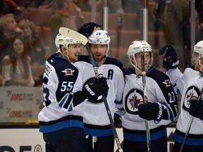 Blake Wheeler (26) celebrates with centre Mark Scheifele (55), right wing Nikolaj Ehlers (27) and center Andrew Copp (9) after scoring the winning goal in overtime against the Anaheim Ducks on Tuesday night. (Kirby Lee-USA TODAY Sports photo)