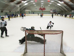 Tyler Parsons is all alone as he does the split to try and stop a shot by Owen MacDonald, as line mates JJ Piccinich and Chandler Yakimowicz wait for a possible rebound at the Knights' practice at Brookside arena in London, Ont. on Wednesday April 6, 2016. 
The Knights start their Western Conference semi finals against Kitchener on Friday at Budweiser Gardens.
Mike Hensen/The London Free Press/Postmedia Network