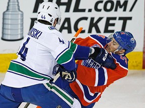 Vancouver Canucks defenseman Matt Bartkowski checks Edmonton Oilers forward Jordan Eberle during the first period at Rexall Place on Apr 6, 2016. (Perry Nelson)