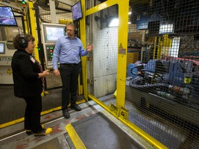 Several pieces of red-hot metal enter a hot stamping press as Formet plant manager Mark Johnson shows Cambridge MPP Kathryn McGarry around the auto parts manufacturer following a $1 million funding announcement at the plant in St. Thomas, Ont. on Thursday April 7, 2016.  The funding, a part of the Southwestern Ontario Development Fund, will help to create 66 new jobs and help with the development of new bumper and structural components for vehicles. (CRAIG GLOVER, The London Free Press)