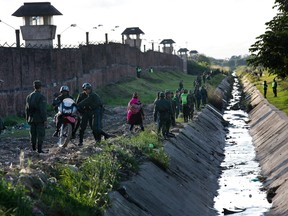 In this July 10, 2015 file photo, soldiers and policemen secure the perimeter of Palmasola prison before the arrival of Pope Francis, in Santa Cruz, Bolivia. Officials told the Associated Press, Thursday, April 7, 2016, that an inmate apparently killed his ex-wife and buried her beneath his cell in at the prison - with nobody taking notice for nearly a year.  (AP Photo/Rodrigo Abd, File)
