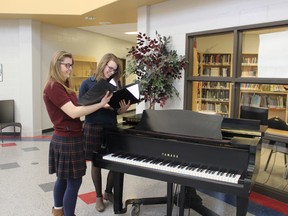 Wilena Veldhuizen and Lydia Byl (left to right) look over their sheet music for Vivaldi's Gloria, one of the pieces the Oxford Reformed Christian School Chamber Choir will be singing at a spring concert. (MEGAN STACEY, Sentinel-Review)