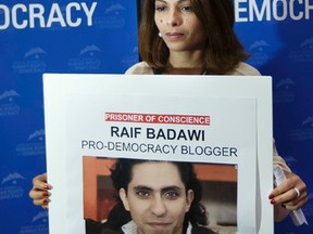 Ensaf Haidar, wife of prisoner of conscience Saudi Arabia's blogger Raif Badawi, holds a picture of her husband, during the 8th Geneva Summit for Human Rights and Democracy, at the International Conference Center Geneva (CICG) in Geneva, Switzerland, Tuesday, Feb. 23, 2016. (Salvatore Di Nolfi/Keystone via AP)