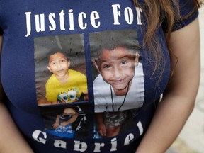 A friend of the family of Gabriel Fernandez, an 8-year-old boy who died in 2013, wears a shirt with his likeness at a news conference in the Sylmar district of Los Angeles, Thursday, April 7, 2016. Prosecutors charged four Los Angeles County social workers with child abuse, saying they were so negligent in handling the case of the young boy who died of gruesome, multiple injuries that, just like his abusers, they were criminally responsible. Gabriel's mother, Pearl Fernandez, and her boyfriend, Isauro Aguirre, have pleaded not guilty to murder and are in jail awaiting trial. (AP Photo/Nick Ut)