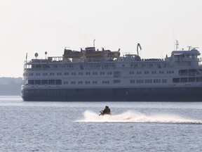 A personal watercraft passes the Great Lakes cruise ship M.S. Saint Laurent while it was moored off Kingston, Ont. on Tuesday July 28, 2015.  Great Lakes cruise ships are becoming more common, and Sarnia Mayor Mike Bradley believes his city should become a port of call. Elliot Ferguson/Kingston Whig-Standard/Postmedia Network