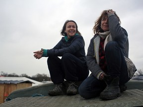 In this Feb. 4, 2016 photo, volunteer Liz Clegg, right, poses with her daughter Inca Sorrell, in the migrant camp of Calais, north of France. The text message from a young boy, writing in broken English on a no-frills cellphone, was frightening enough to set off a frantic, trans-Atlantic search that saved the lives of 15 migrants trapped in a locked truck in England. The message flashed on the cellphone of volunteer Liz Clegg, who in March had handed out hundreds of basic cellphones to children living in the squalid migrant camp in Calais, France, and told them to text in any crisis. (AP Photo/Thibault Camus)