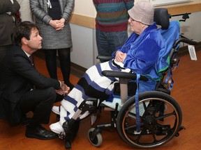 Tim Miller/The Intelligencer
Minister of Health and Long-term Care Dr. Eric Hoskins crouches down to speak with Gail Grundle, an inpatient at Trenton Memorial Hospital on Friday. Hoskins was at TMH to announce an increase in funding for Quinte Health Care and a pause on the movement of day surgeries away from TMH.
